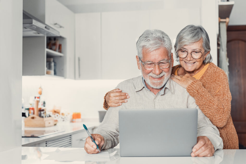 Old age and modern tech. Retired family couple sit at kitchen ta